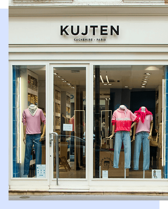 A store front with two mannequins in pink shirts and jeans.
