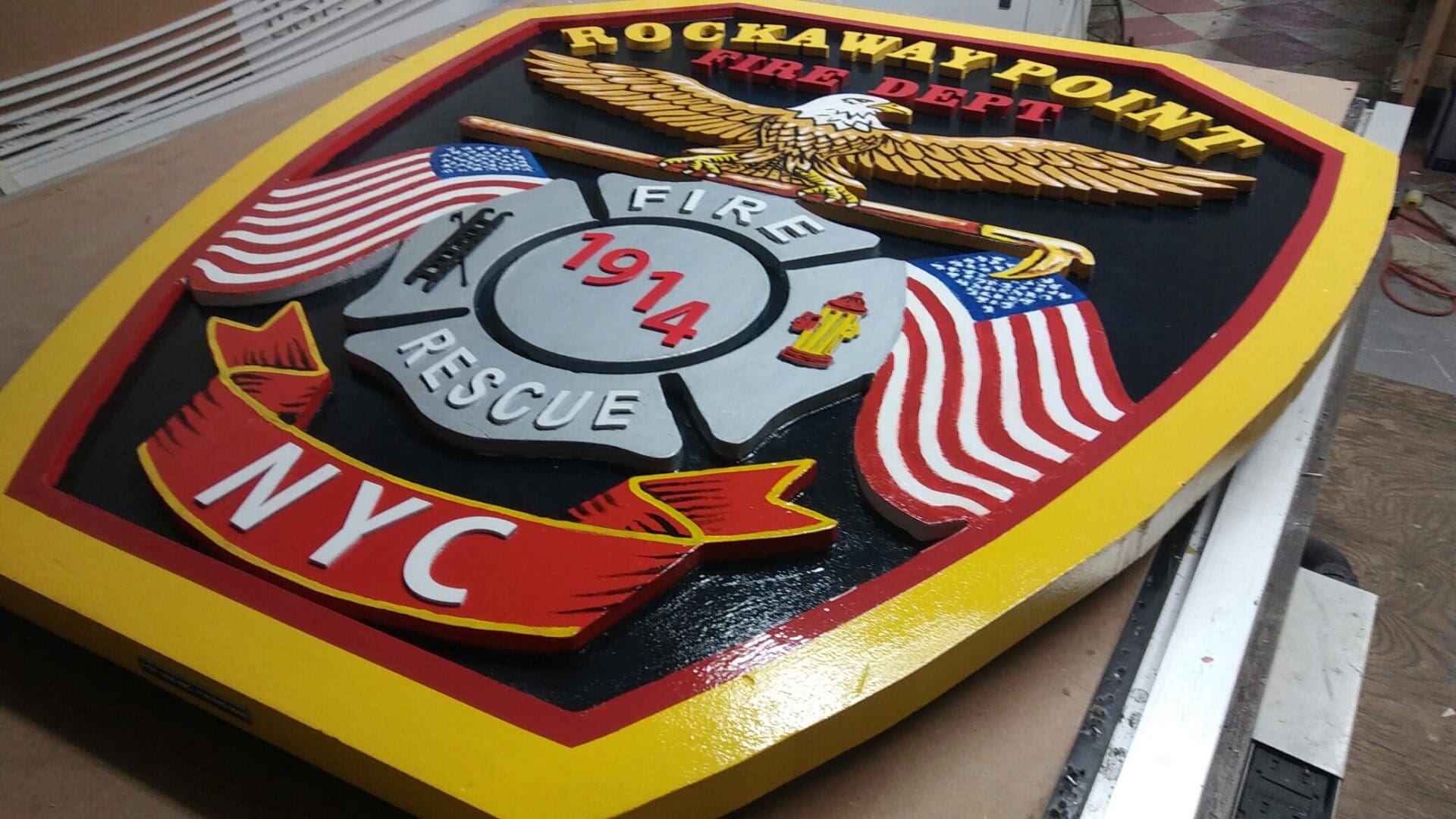 A colorful emblem of the Rockaway Point Fire Department featuring symbols of eagles, flags, and the ADP USA initials, dated 1914.