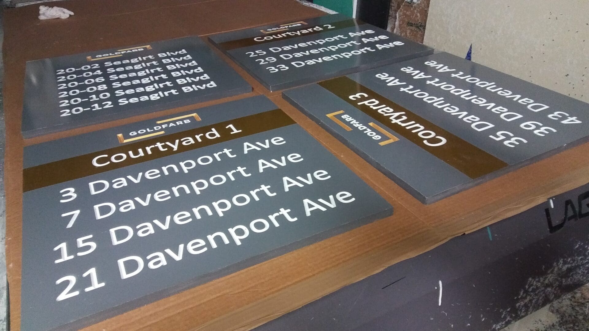 Stack of various street signs on a concrete floor, including multiple signs for Davenport Ave with different house numbers, curated for the ADP USA Solutions Gallery.