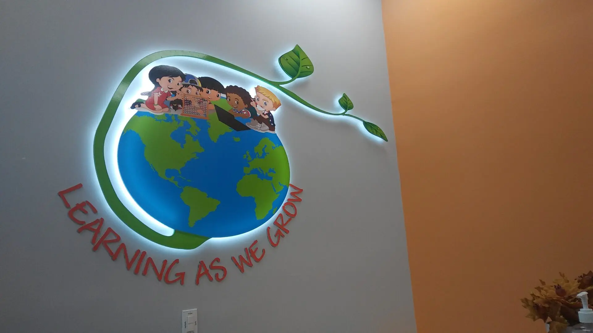 Wall mural depicting a stylized globe with diverse children on it and the phrase 